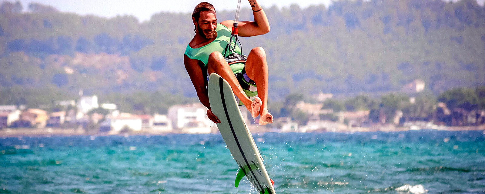 kitesurfer mit surfkiteboard in der hand im sprung über den wellen