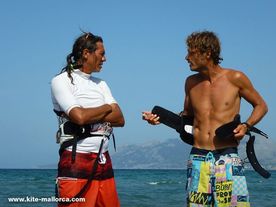 A couple of men standing on top of a beach .