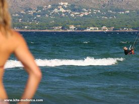 A women observing a men helping a child in kiteboarding