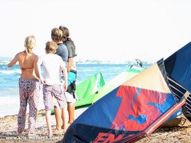 Daniel and Gerhard with students watching kitesurfers A group of people looking to the sea and talking about